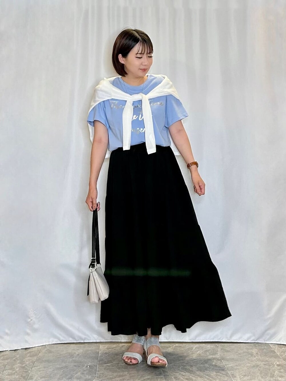 ホワイト系のカーディガン/ボレロ、ブルー系のTシャツ/カットソー、ブラック系のスカートを着用したレディースの夏コーディネートの1枚目の写真