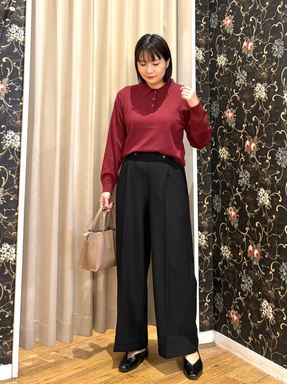レッド系のニット/セーター、ブラック系のその他パンツ、ベージュ系のトートバッグを着用したレディースの秋コーディネートの1枚目の写真