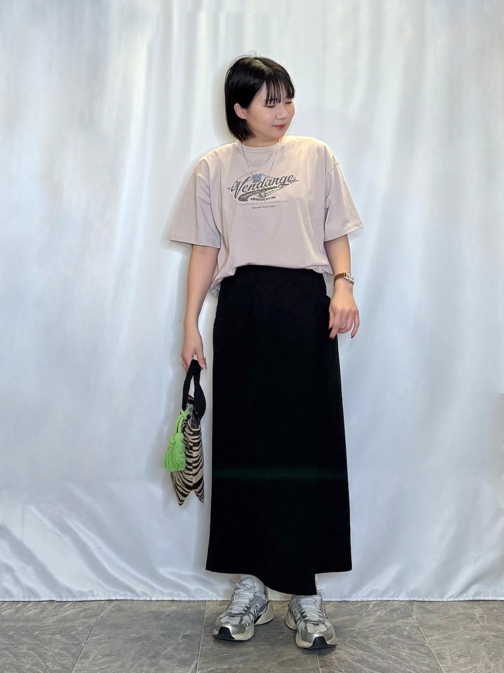 ブラック系のトートバッグ、ブラック系のスカート、ブラウン系のTシャツ/カットソーを着用したレディースの春コーディネートの1枚目の写真