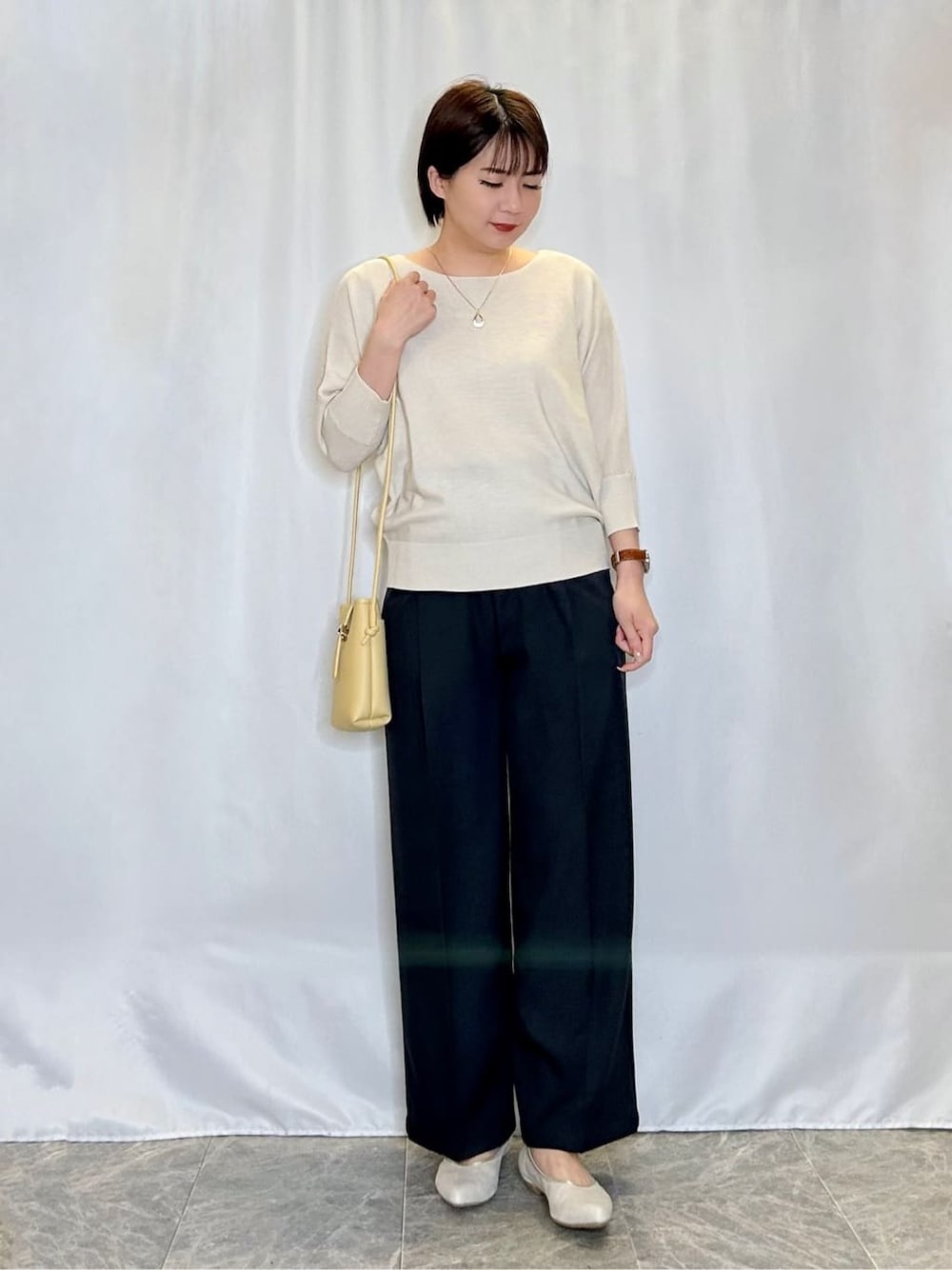 ホワイト系のニット/セーター、グレー系のその他パンツ、ゴールド系のその他シューズを着用したレディースの春コーディネートの1枚目の写真