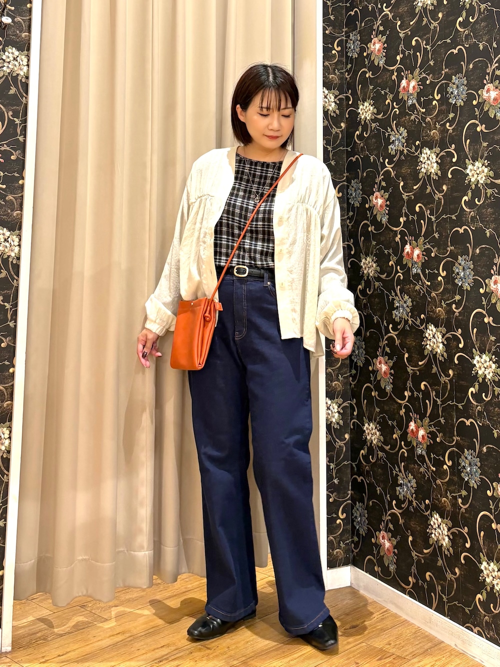 ホワイト系のカーディガン/ボレロ、ブラック系のTシャツ/カットソー、ブルー系のデニムパンツを着用したレディースの秋コーディネートの1枚目の写真