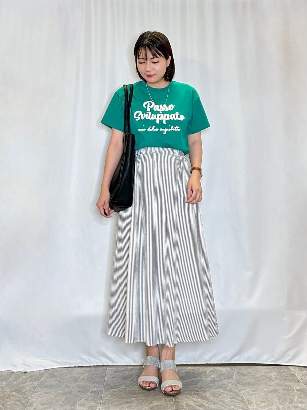 グリーン系のTシャツ/カットソー、グレー系のスカート、シルバー系のサンダルを着用したレディースの夏コーディネートの1枚目の写真