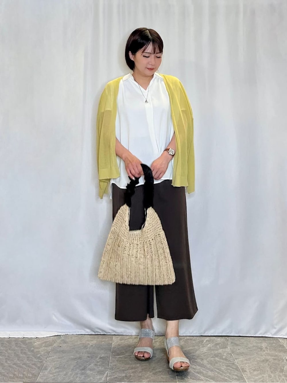 イエロー系のカーディガン/ボレロ、ホワイト系のシャツ/ブラウス、ブラウン系のその他パンツを着用したレディースの夏コーディネートの1枚目の写真