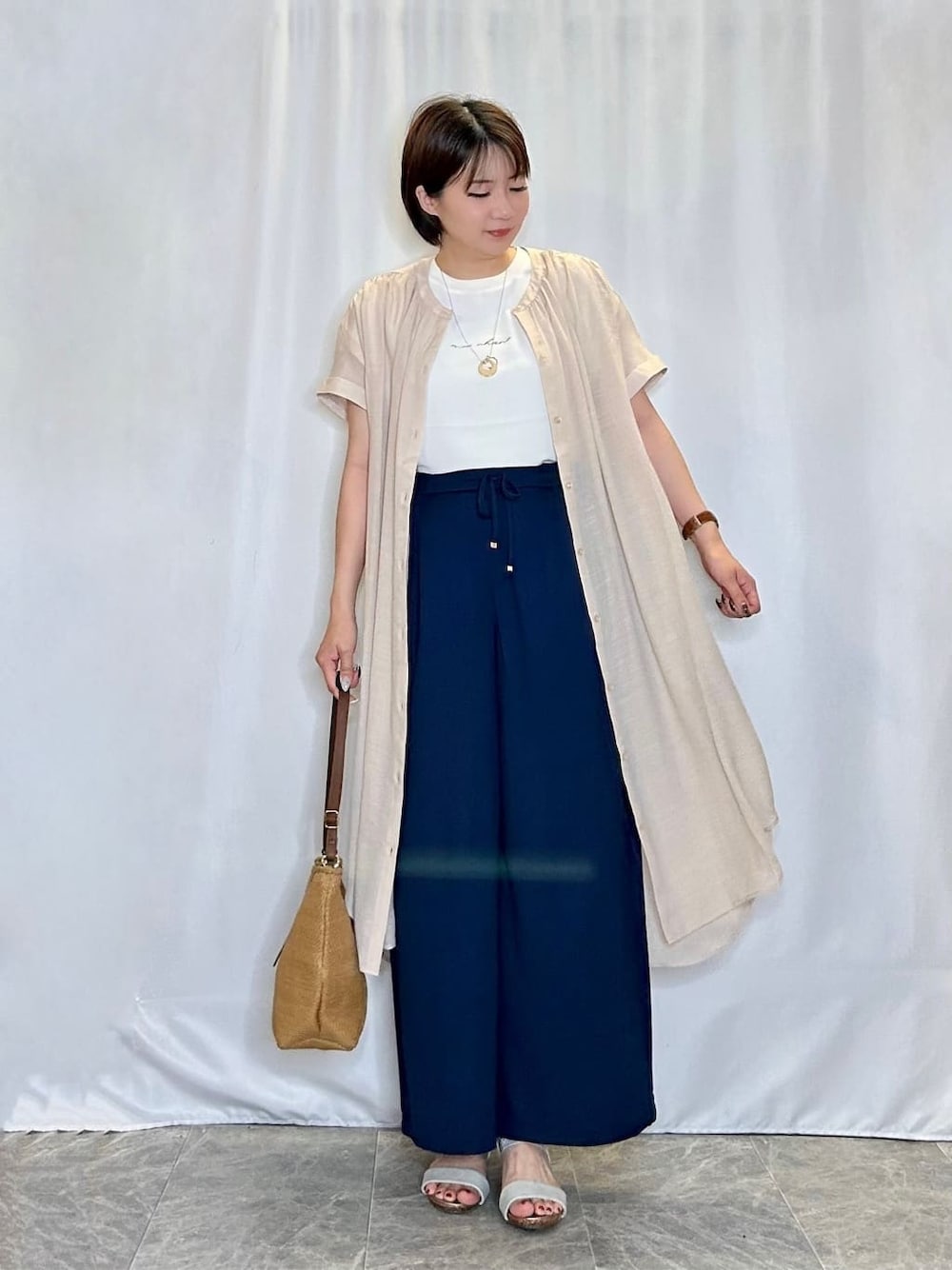 ベージュ系のワンピース、ホワイト系のシャツ/ブラウス、ブルー系のその他パンツを着用したレディースの夏コーディネートの1枚目の写真