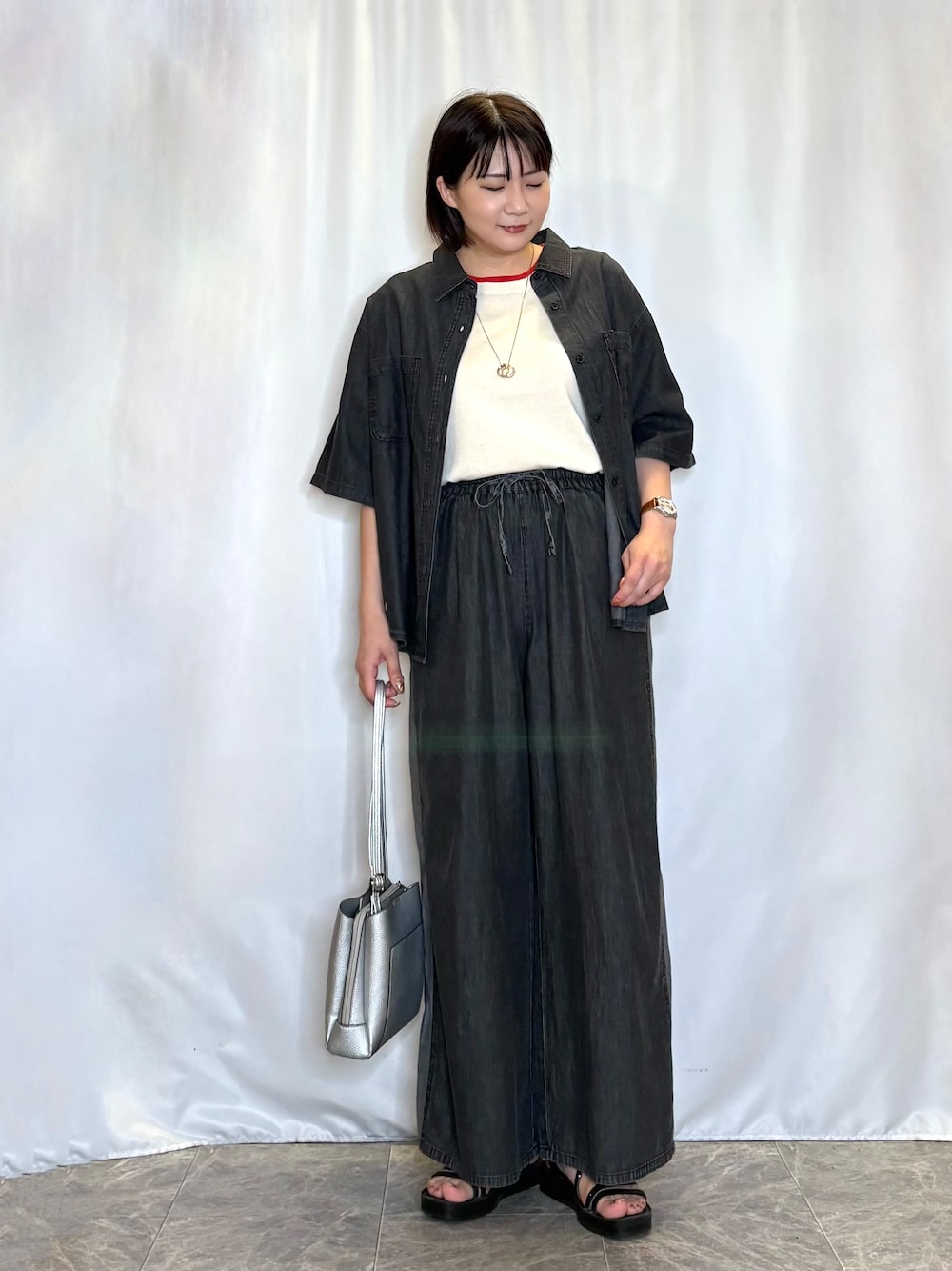 ブラック系のシャツ/ブラウス、ホワイト系のニット/セーター、グレー系のデニムパンツを着用したレディースの夏コーディネートの1枚目の写真