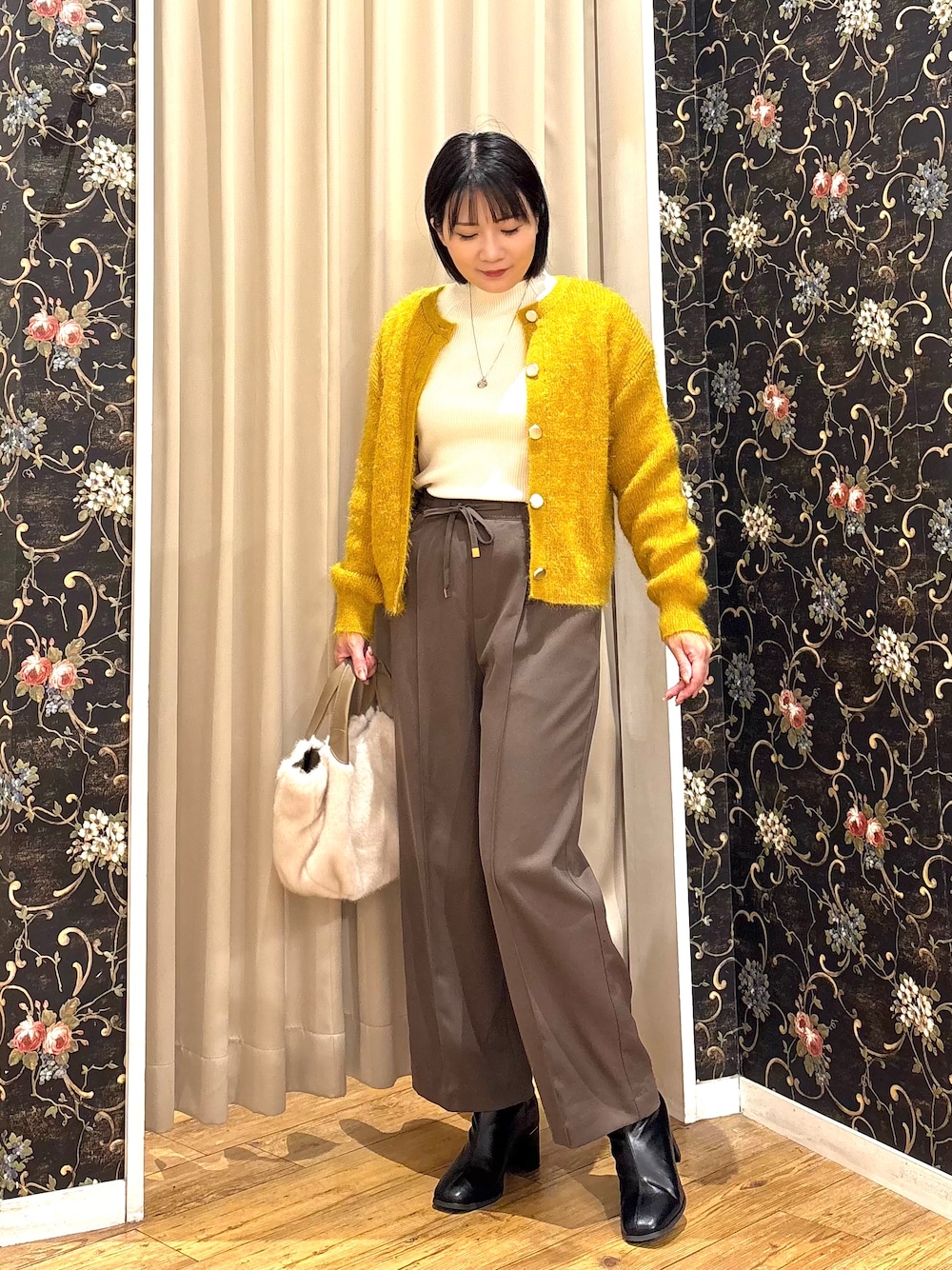イエロー系のカーディガン/ボレロ、ホワイト系のニット/セーター、ブラウン系のその他パンツを着用したレディースの秋コーディネートの1枚目の写真
