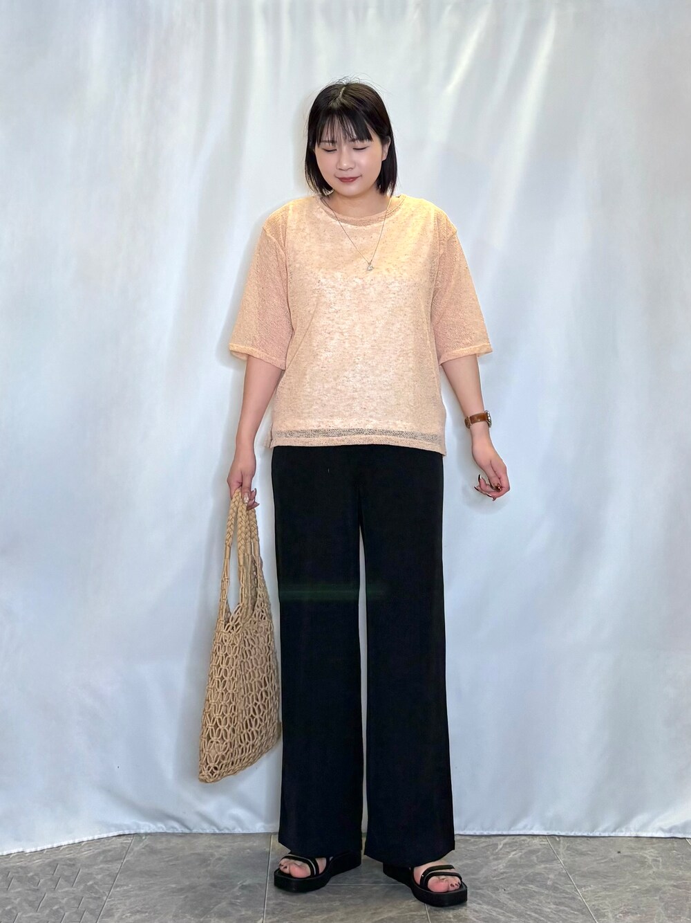オレンジ系のその他トップス、ブラック系のその他パンツ、ブラック系のサンダルを着用したレディースの春コーディネートの1枚目の写真