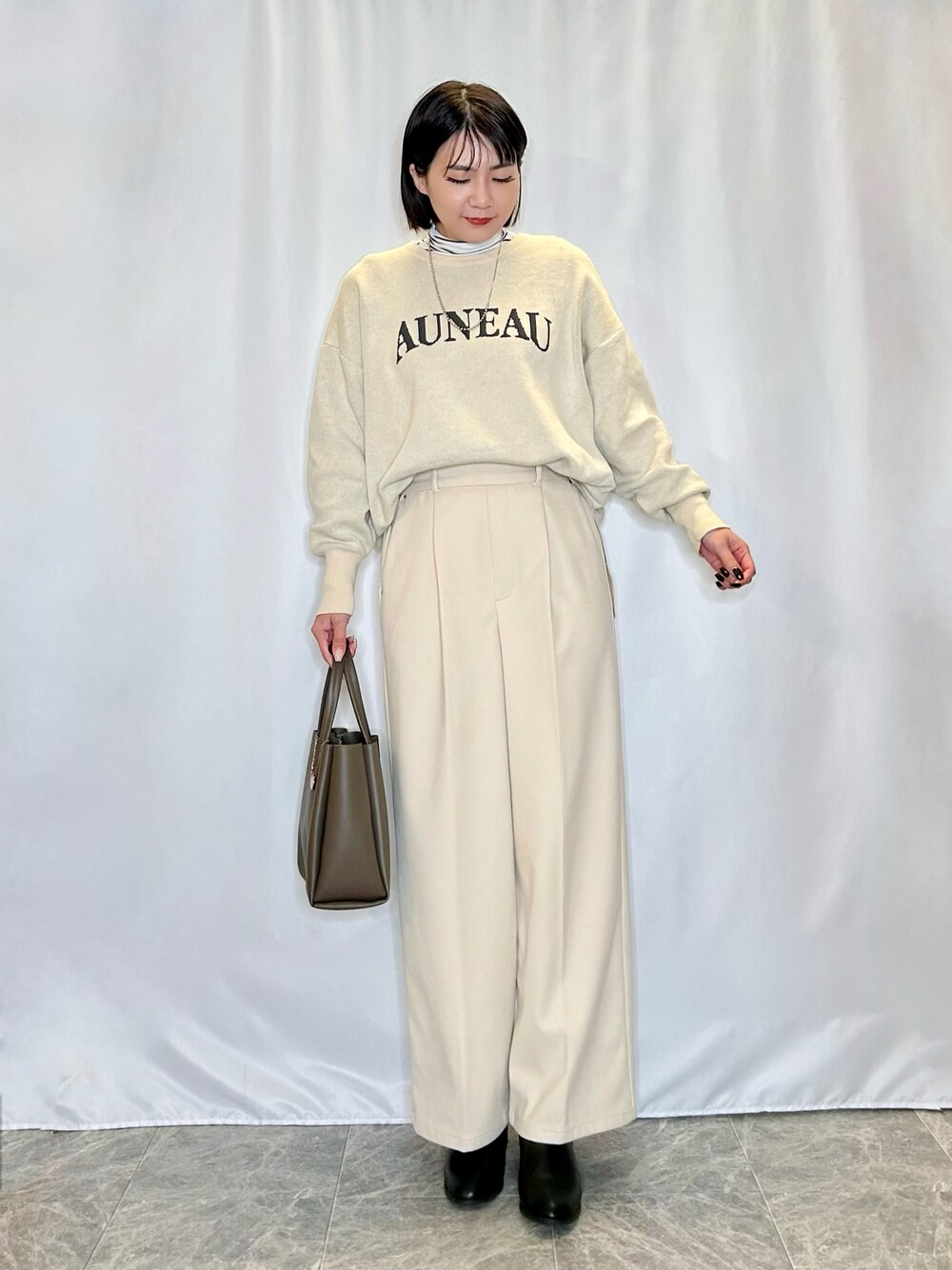 ホワイト系のTシャツ/カットソー、ホワイト系のニット/セーター、ブラック系のブーツを着用したレディースの冬コーディネートの1枚目の写真