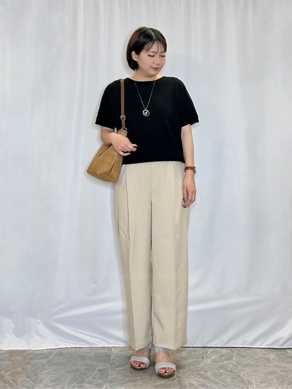 ブラック系のニット/セーター、ベージュ系のその他パンツ、シルバー系のサンダルを着用したレディースの夏コーディネートの1枚目の写真