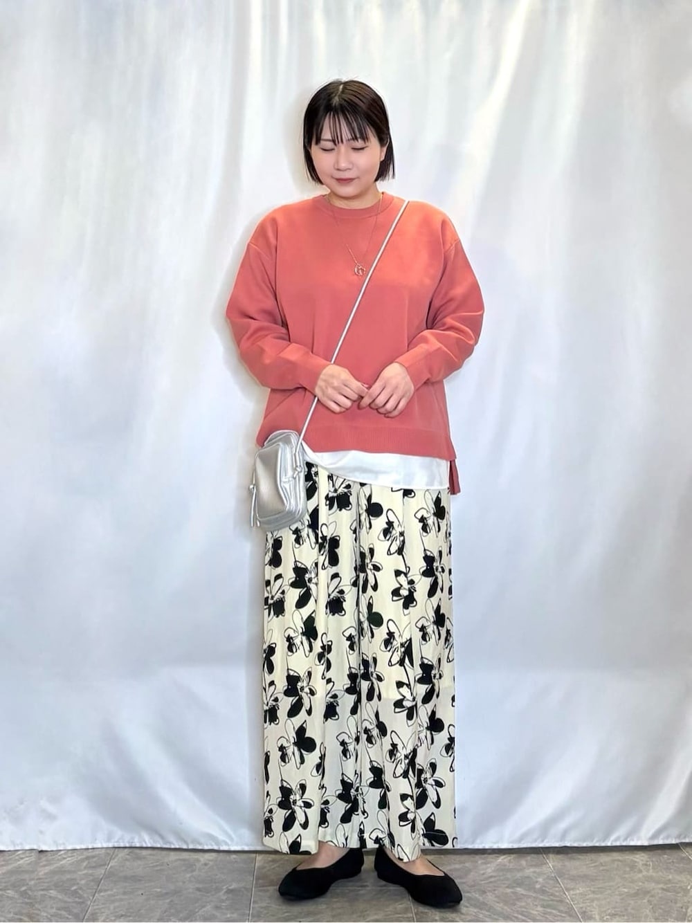 ピンク系のニット/セーター、ベージュ系のその他パンツ、ブラック系のパンプスを着用したレディースの春コーディネートの1枚目の写真