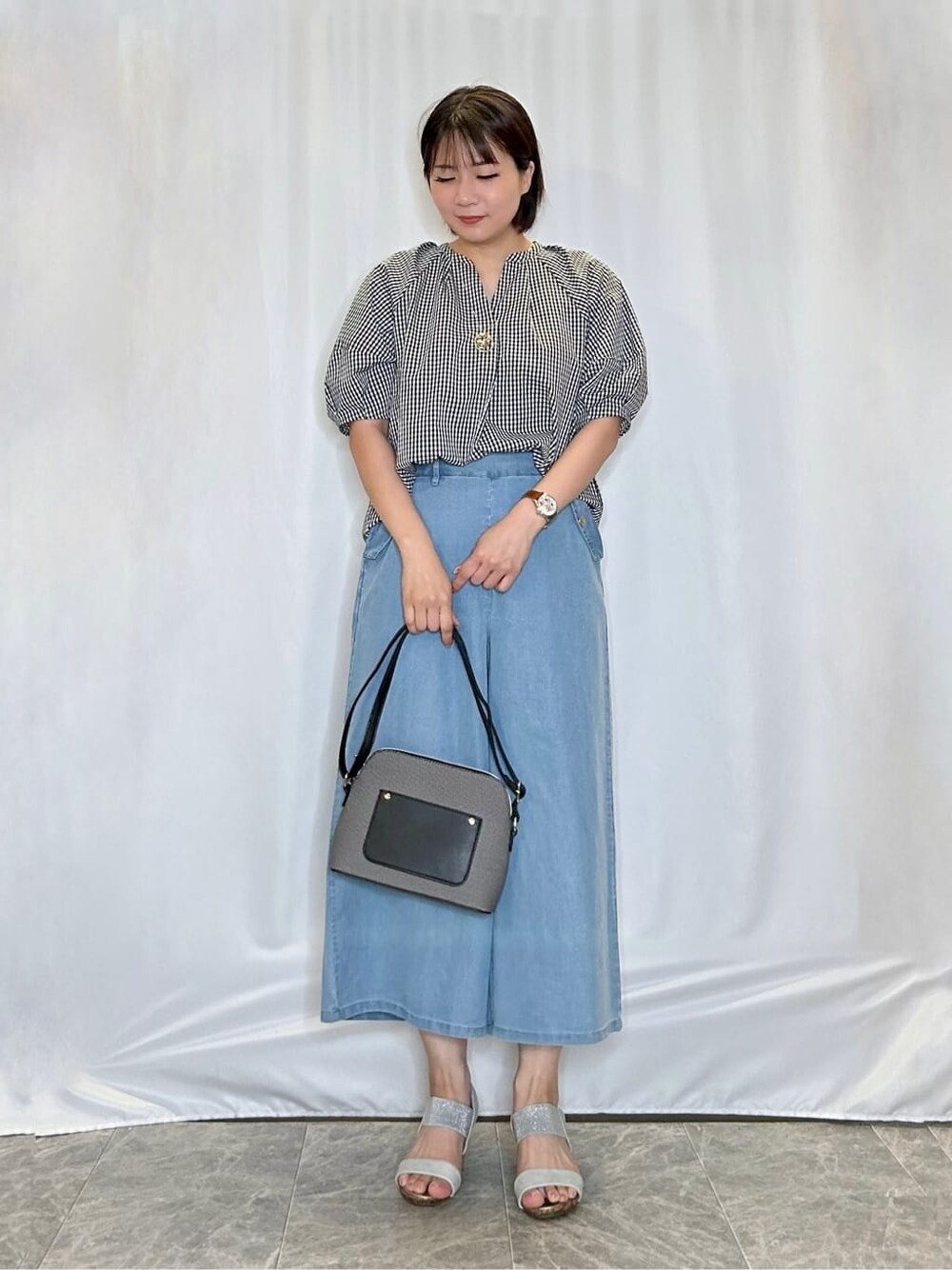 ブラック系のシャツ/ブラウス、ブルー系のデニムパンツ、シルバー系のサンダルを着用したレディースの夏コーディネートの1枚目の写真