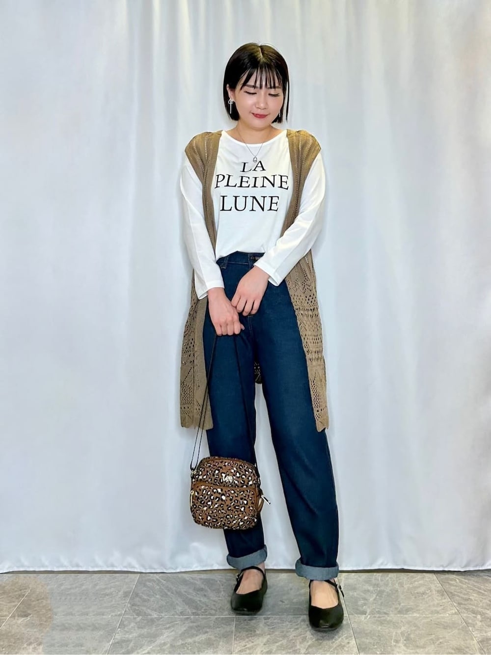ブルー系のデニムパンツを着用したレディースの秋コーディネートの1枚目の写真