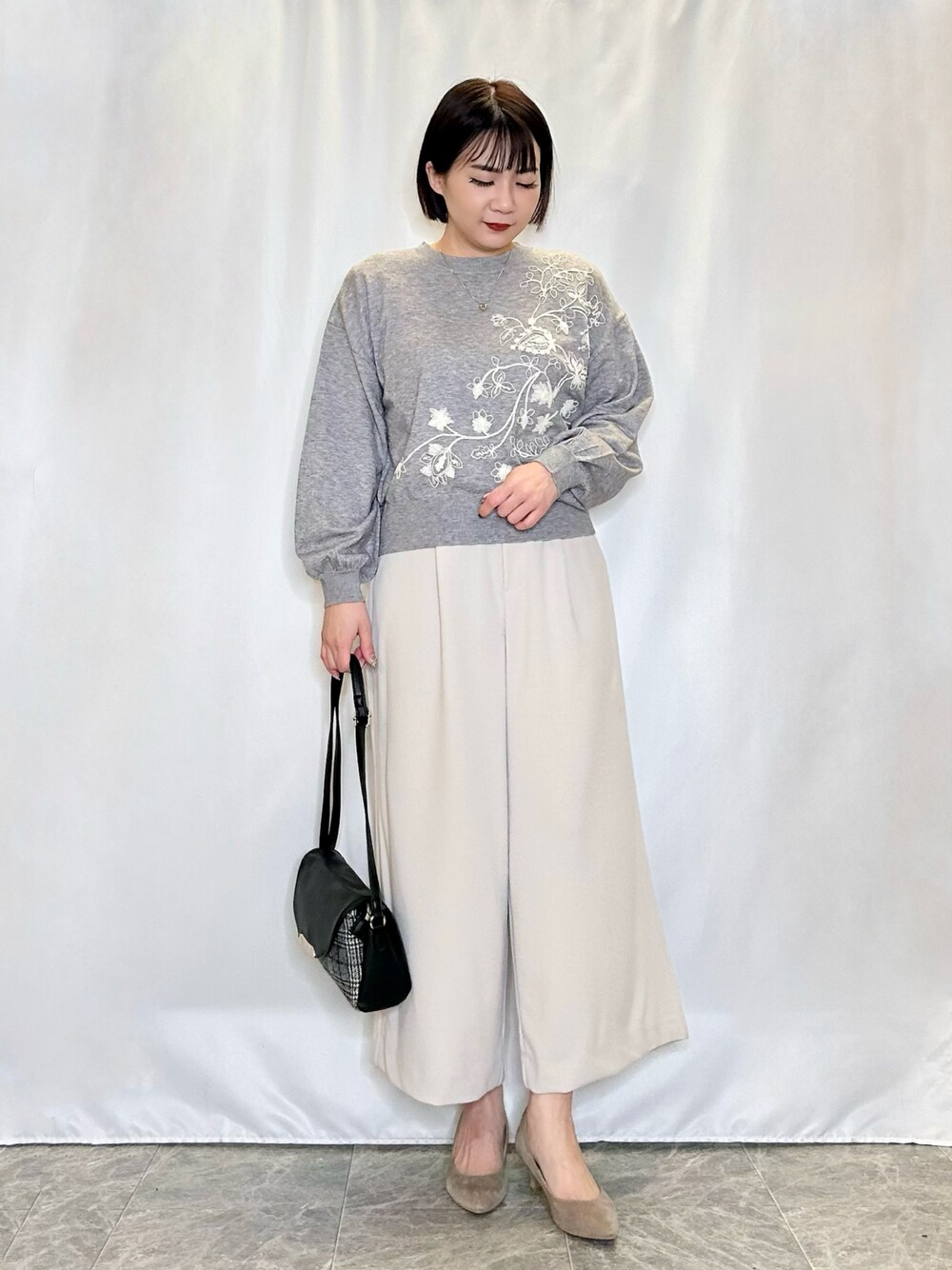 ベージュ系のその他パンツ、ブラック系のショルダーバッグ、ベージュ系のパンプスを着用したレディースの冬コーディネートの1枚目の写真