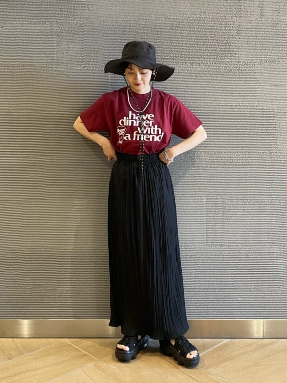 ブラック系のスカート、ブラック系のサンダル、レッド系のTシャツ/カットソーを着用したレディースの夏コーディネートの1枚目の写真