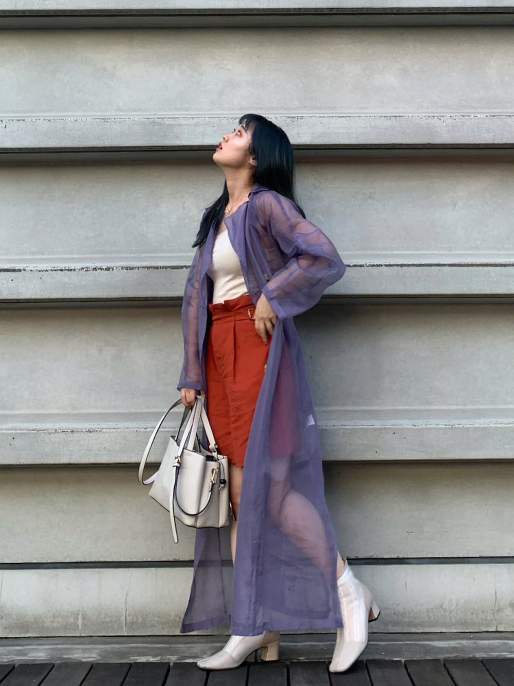 ベージュ系のバッグ、ベージュ系のブーツ、オレンジ系のその他パンツを着用したレディースの秋コーディネートの1枚目の写真