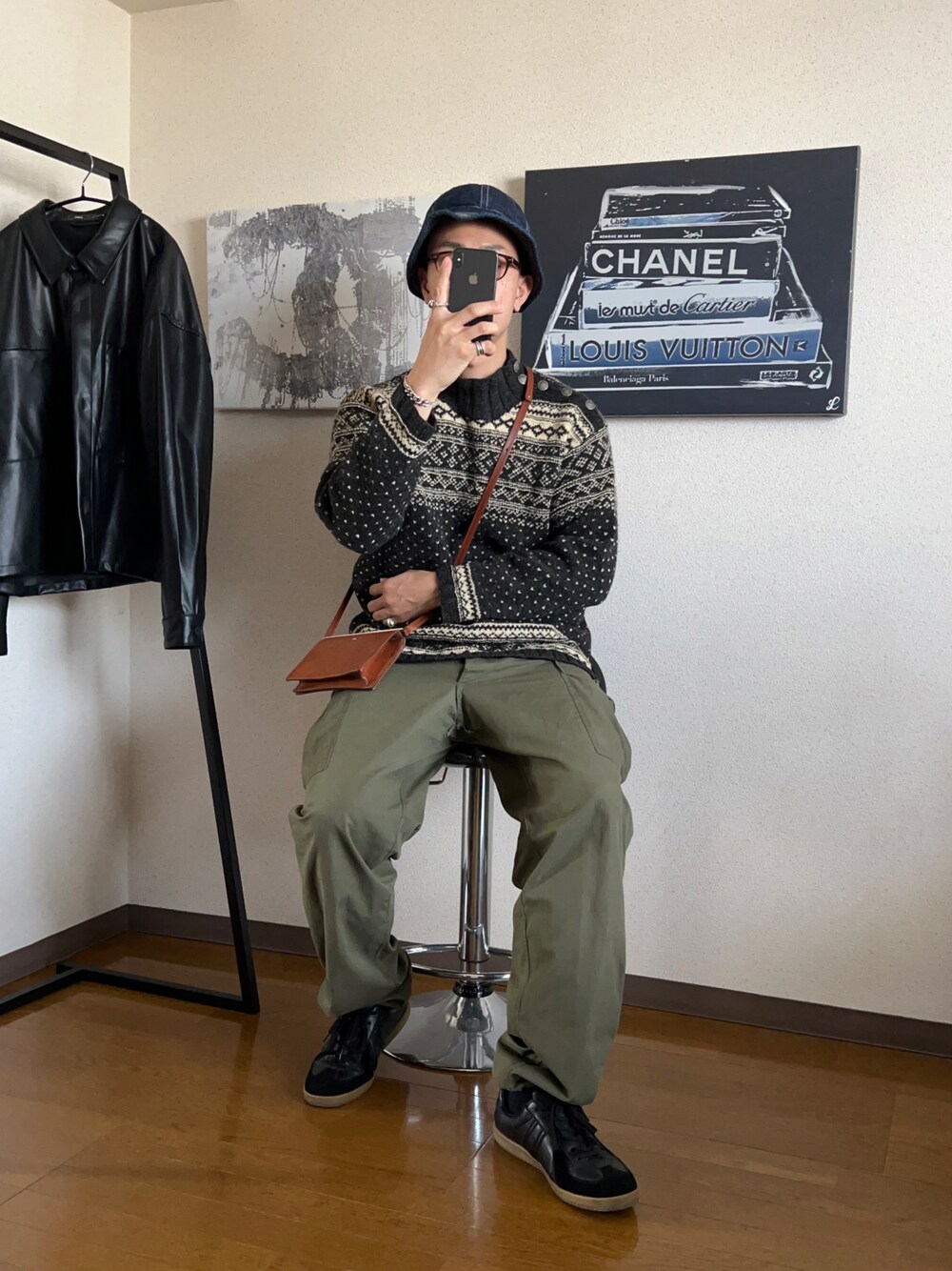 ブラック系のニット/セーター、グリーン系のカーゴパンツを着用したメンズの春コーディネートの1枚目の写真