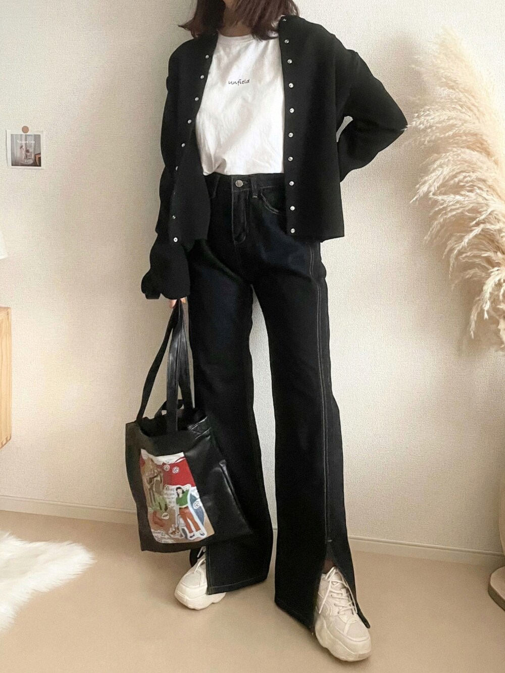 ブラック系のカーディガン/ボレロ、ブルー系のデニムパンツ、ブラック系のトートバッグを着用したレディースの秋コーディネートの1枚目の写真