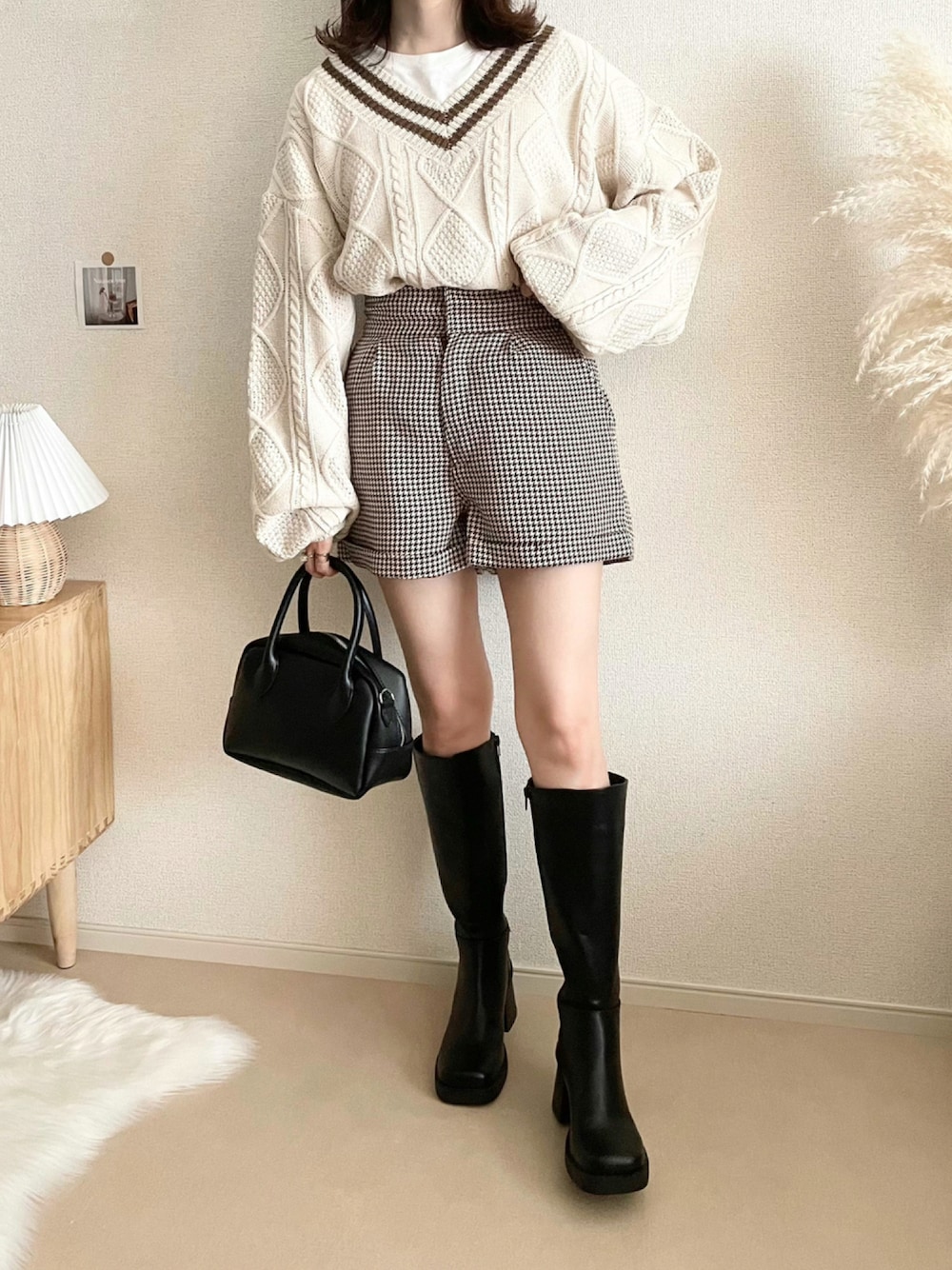 ホワイト系のニット/セーター、ブラウン系のその他パンツ、ブラック系のボストンバッグを着用したレディースの秋コーディネートの1枚目の写真