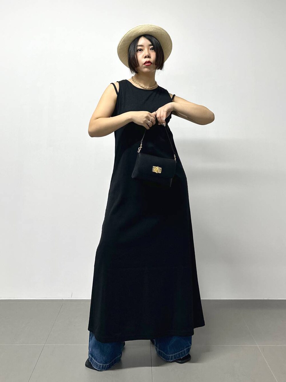 ブラック系のショルダーバッグ、ブルー系のデニムパンツ、その他のサンダルを着用したレディースの夏コーディネートの1枚目の写真