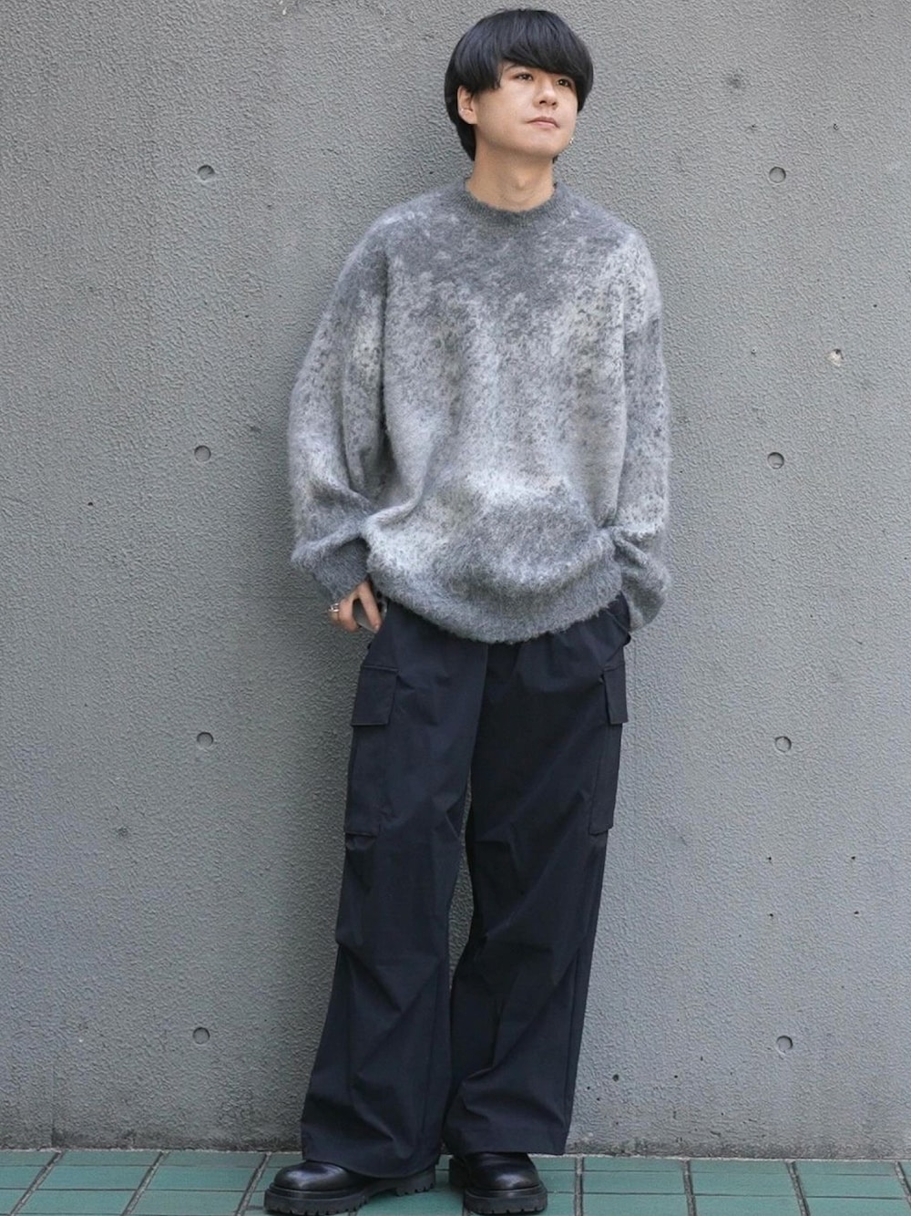 グレー系のニット/セーター、ブラック系のブーツ、シルバー系のピアス(片耳用)を着用したメンズの冬コーディネートの1枚目の写真