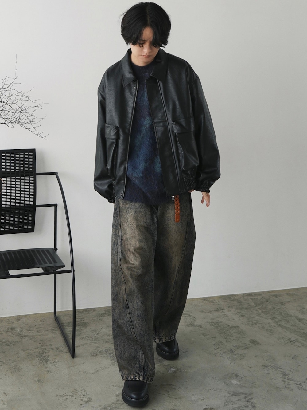 ブラック系のブルゾン、ブルー系のニット/セーター、ブルー系のデニムパンツを着用したメンズの秋コーディネートの1枚目の写真