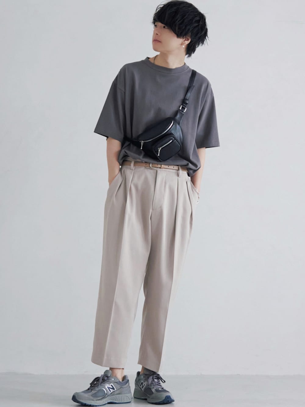 ブラウン系のTシャツ/カットソー、ベージュ系のスラックス、ブラック系のボディバッグ/ウエストポーチを着用したメンズの夏コーディネートの1枚目の写真