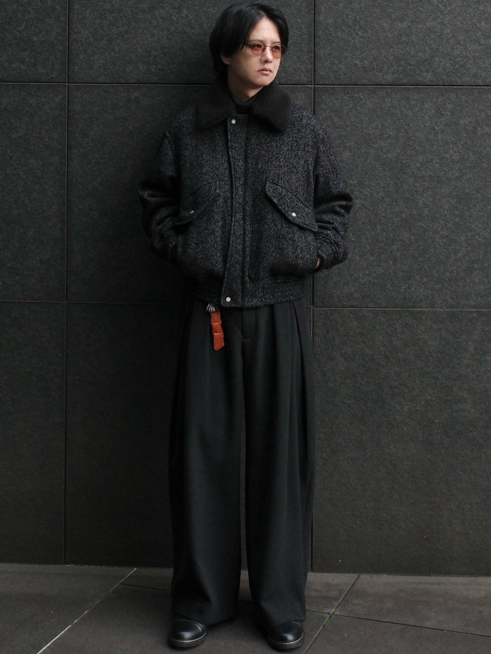 グレー系のニット/セーター、ブラック系のジャケット/アウター、グレー系のパンツを着用したメンズの秋コーディネートの1枚目の写真