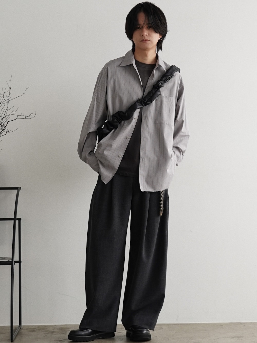 グレー系のTシャツ/カットソー、グレー系のスラックス、ブラック系のショルダーバッグを着用したメンズの夏コーディネートの1枚目の写真