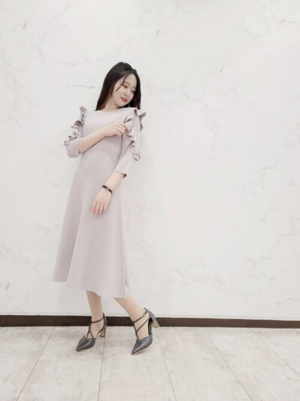グレー系のワンピース、グレー系のパンプスを着用したレディースの春コーディネートの1枚目の写真