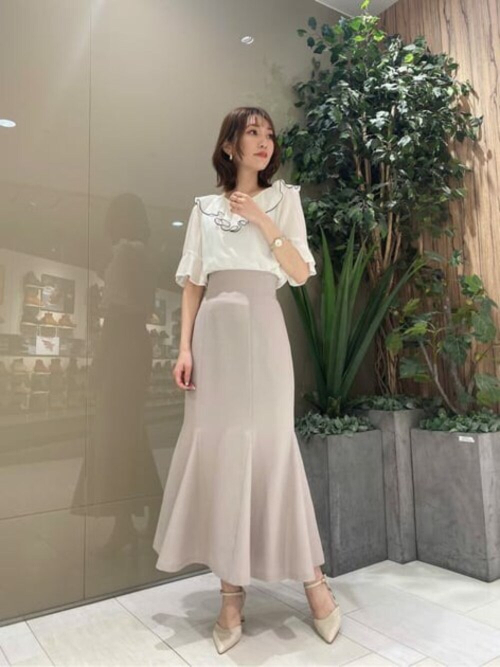 ホワイト系のシャツ/ブラウス、ベージュ系のスカートを着用したレディースの春コーディネートの1枚目の写真