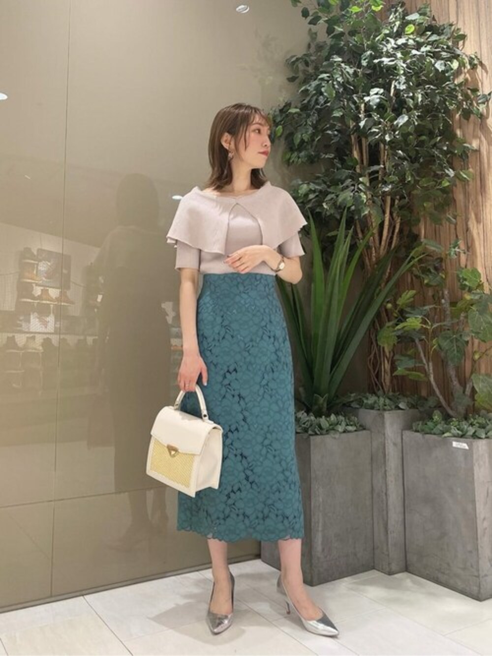 グレー系のニット/セーター、グリーン系のスカートを着用したレディースの春コーディネートの1枚目の写真