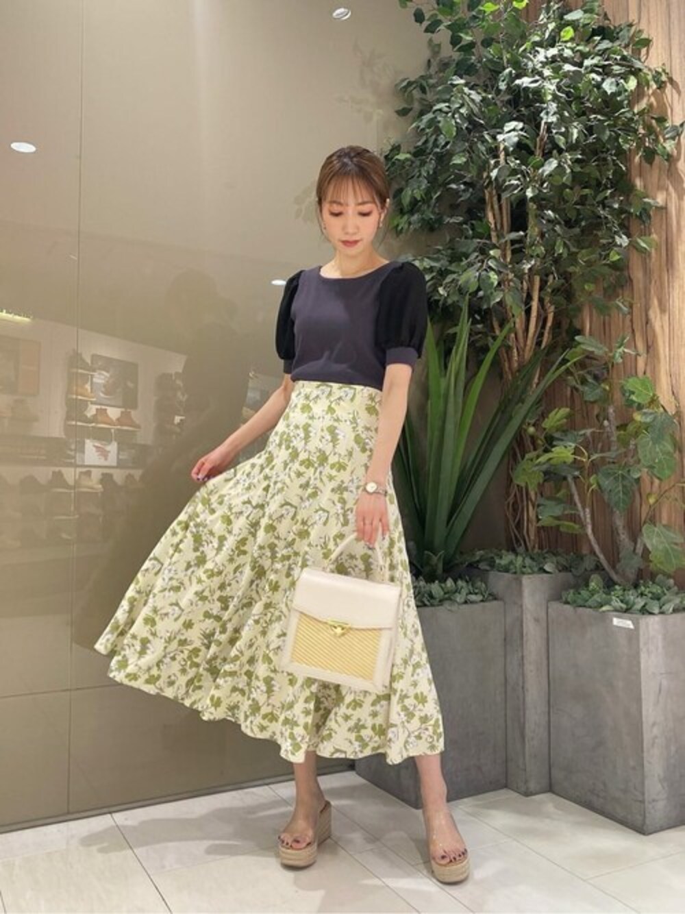 グレー系のTシャツ/カットソー、ホワイト系のスカート、ホワイト系のショルダーバッグを着用したレディースの春コーディネートの1枚目の写真