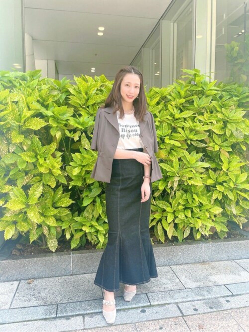 ブラウン系のテーラードジャケット、ブラック系のスカート、ホワイト系のTシャツ/カットソーを着用したレディースの春コーディネートの1枚目の写真