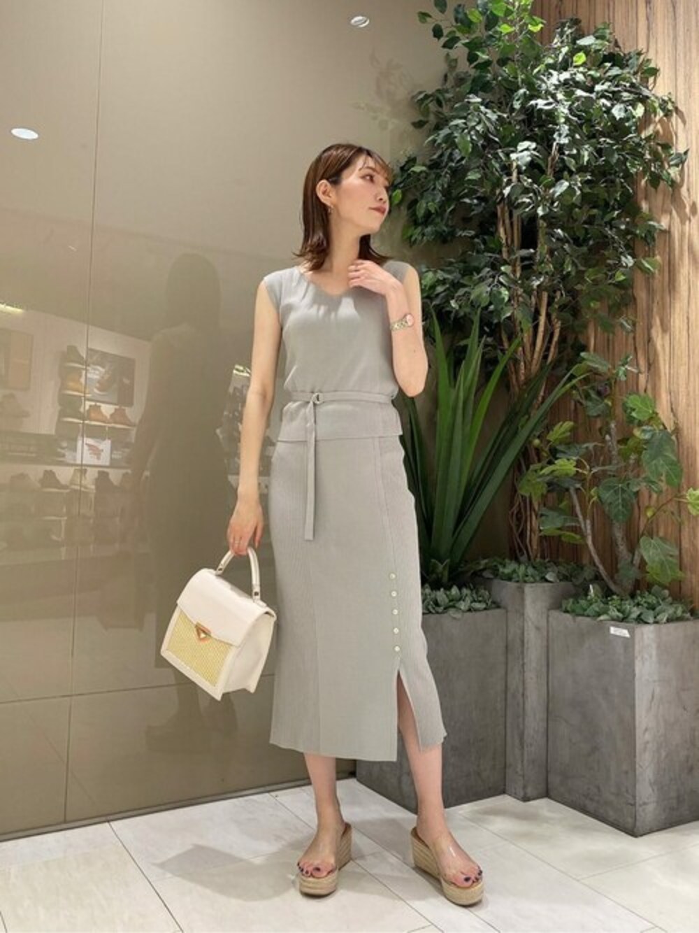 グリーン系のワンピース、ホワイト系のショルダーバッグを着用したレディースの夏コーディネートの1枚目の写真