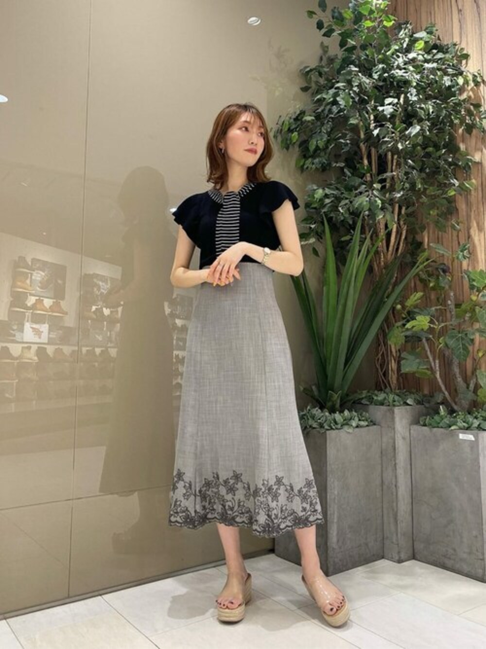 ブラック系のニット/セーター、ブラック系のスカートを着用したレディースの夏コーディネートの1枚目の写真