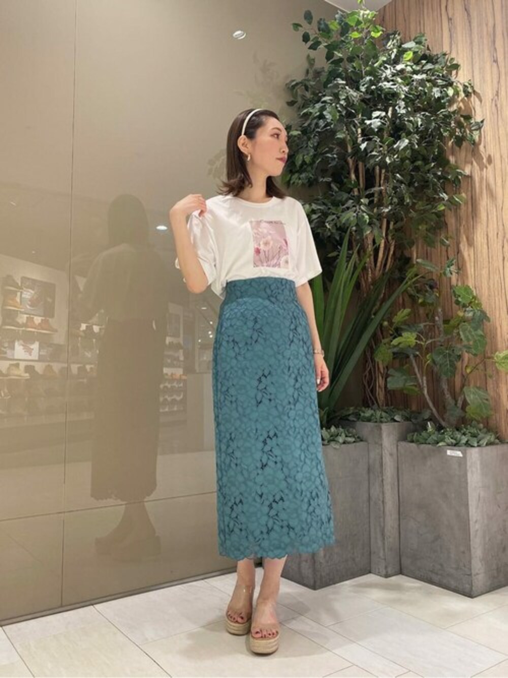 ホワイト系のTシャツ/カットソー、グリーン系のスカートを着用したレディースの夏コーディネートの1枚目の写真