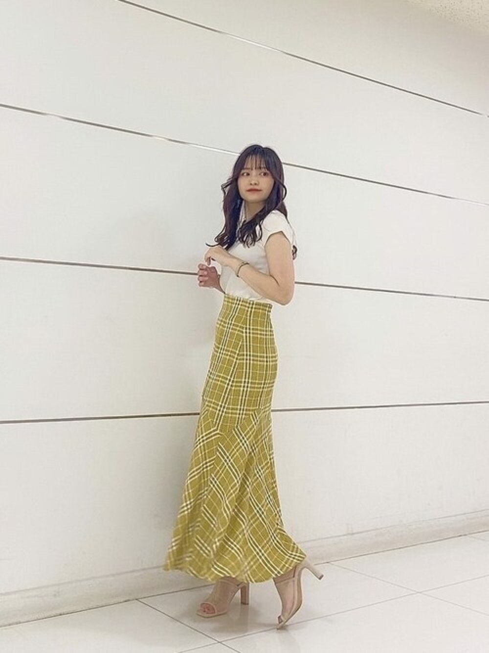 ホワイト系のニット/セーター、イエロー系のスカートを着用したレディースの夏コーディネートの1枚目の写真