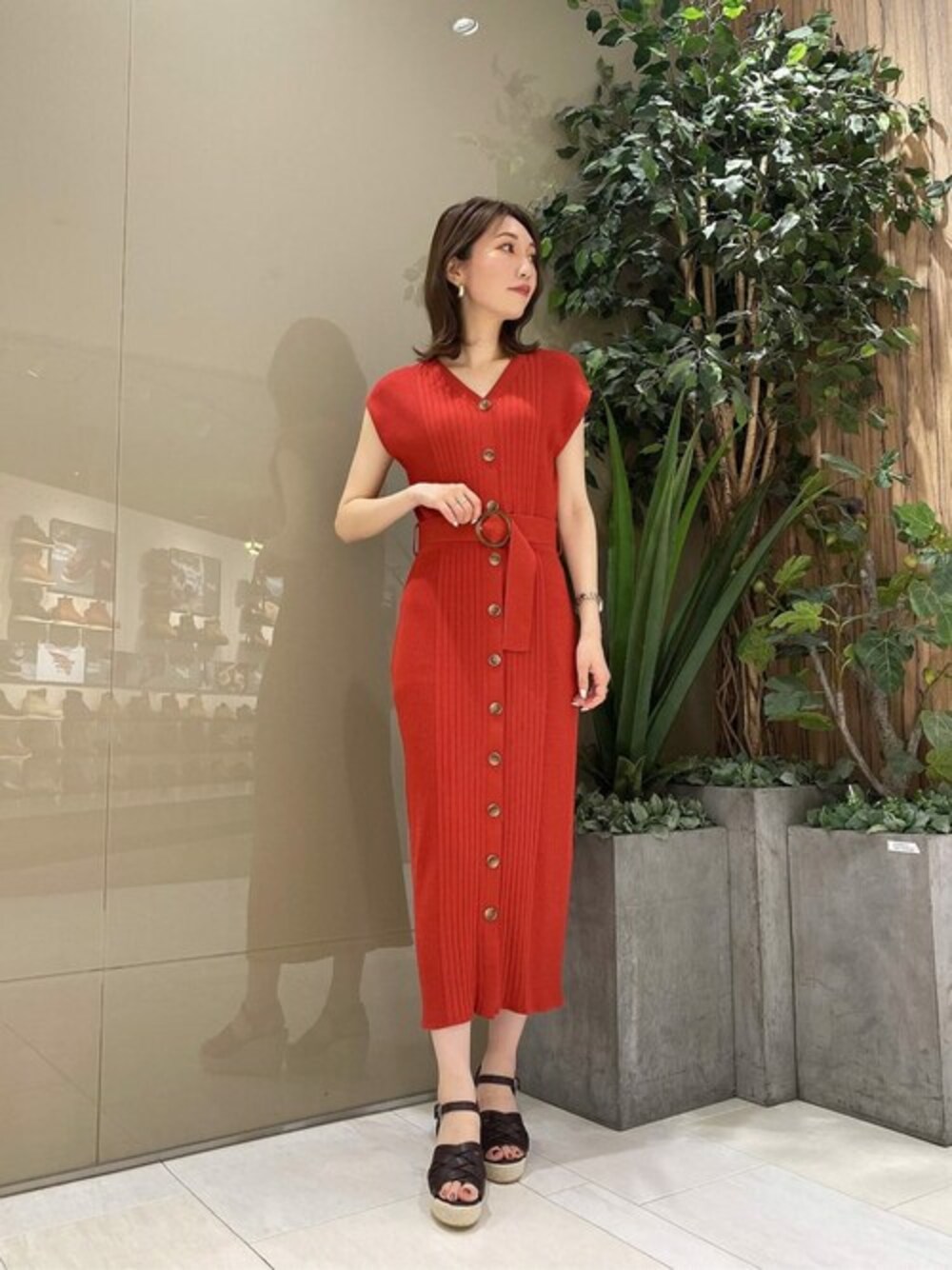 オレンジ系のワンピース、ブラウン系のパンプスを着用したレディースの夏コーディネートの1枚目の写真