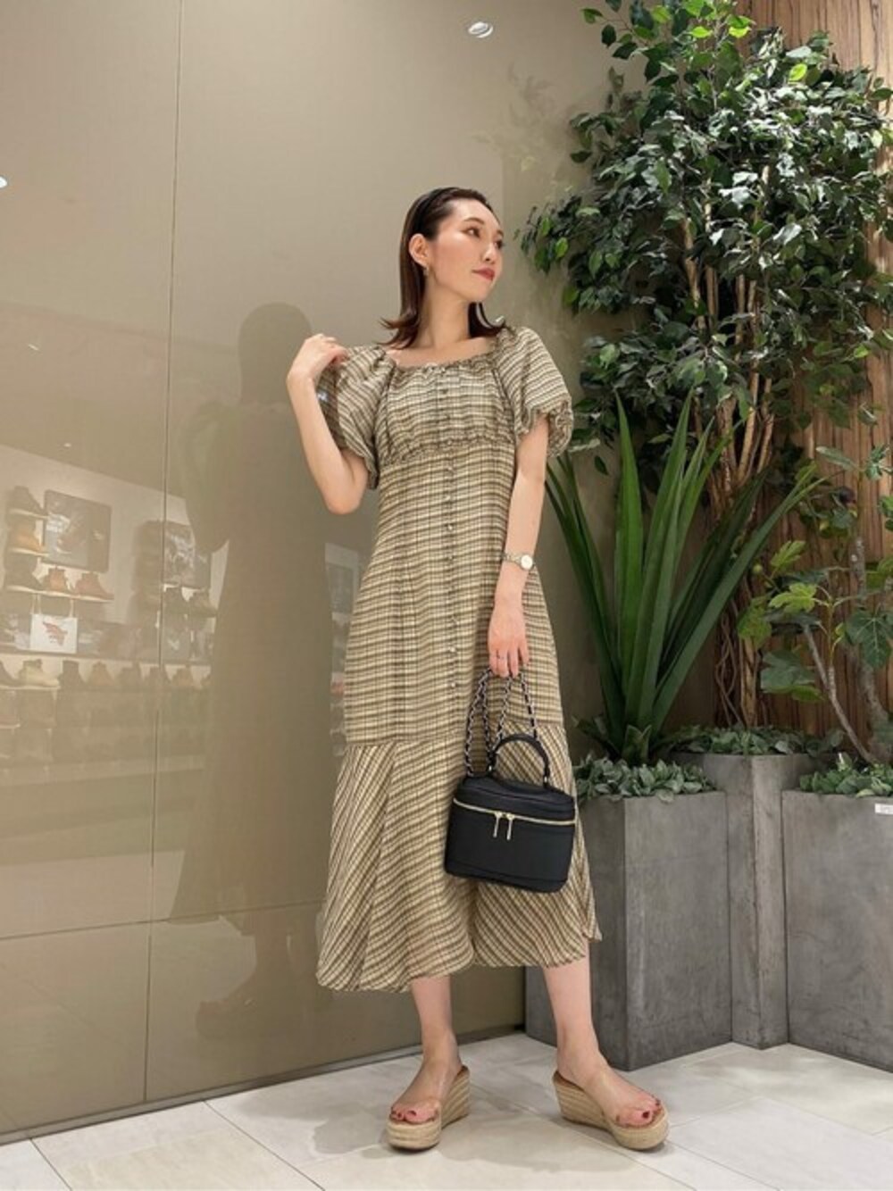 ベージュ系のワンピース、ブラック系のショルダーバッグを着用したレディースの夏コーディネートの1枚目の写真