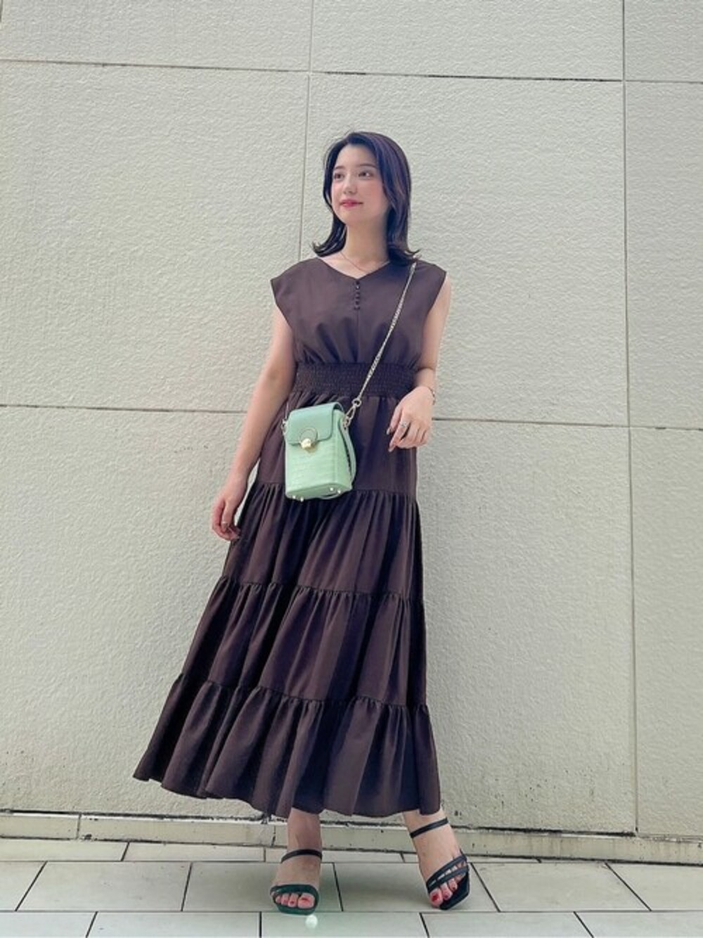 ブラウン系のワンピース、グリーン系のショルダーバッグを着用したレディースの夏コーディネートの1枚目の写真