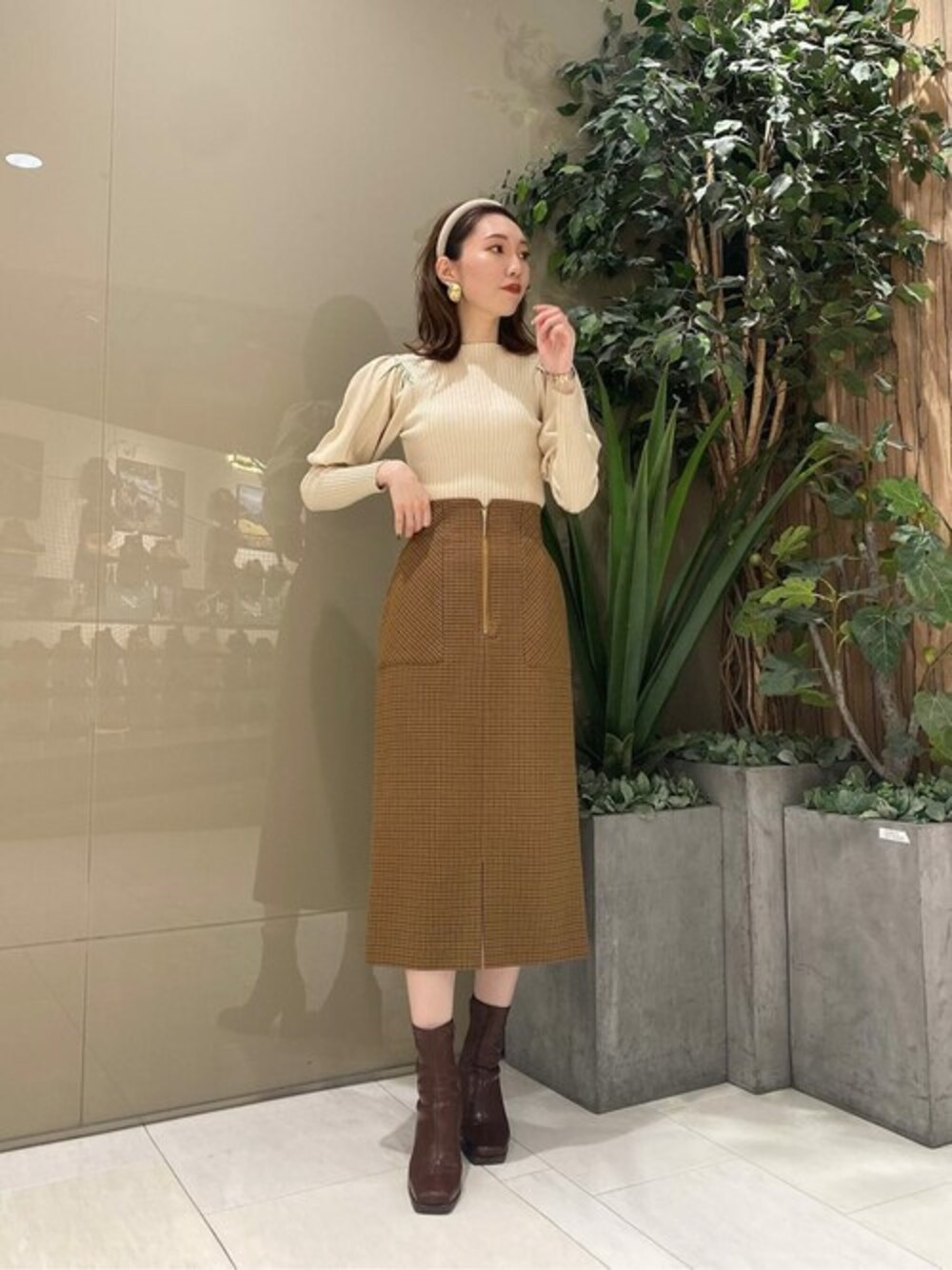 ホワイト系のニット/セーター、ベージュ系のスカートを着用したレディースの秋コーディネートの1枚目の写真