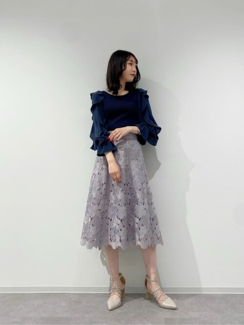 ブルー系のニット/セーター、パープル系のスカートを着用したレディースの冬コーディネートの1枚目の写真