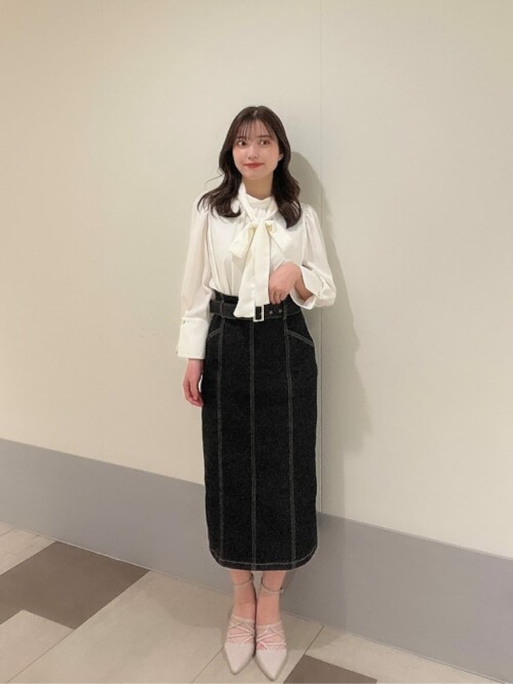 ブラック系のスカート、ホワイト系のシャツ/ブラウス、グレー系のパンプスを着用したレディースの冬コーディネートの1枚目の写真