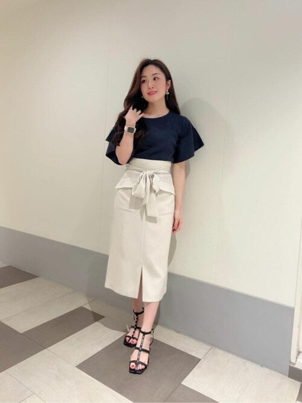 グレー系のニット/セーター、ホワイト系のスカートを着用したレディースの夏コーディネートの1枚目の写真