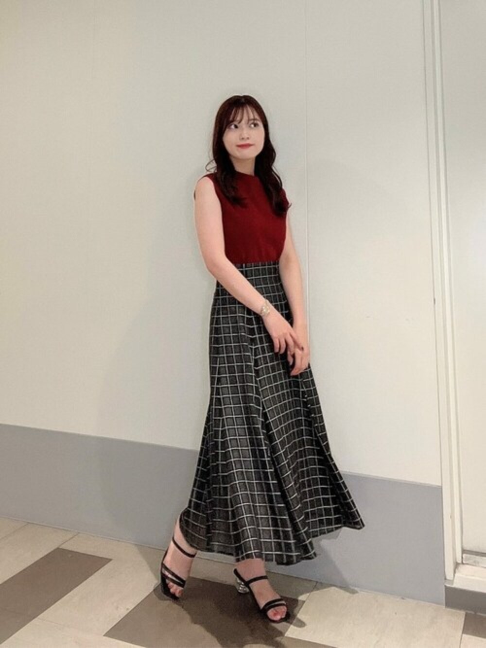 レッド系のニット/セーター、ブラック系のスカートを着用したレディースの夏コーディネートの1枚目の写真