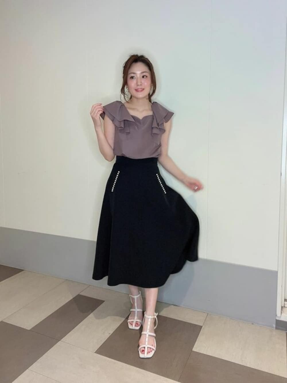 ピンク系のシャツ/ブラウス、ブラック系のスカート、ホワイト系のパンプスを着用したレディースの夏コーディネートの1枚目の写真