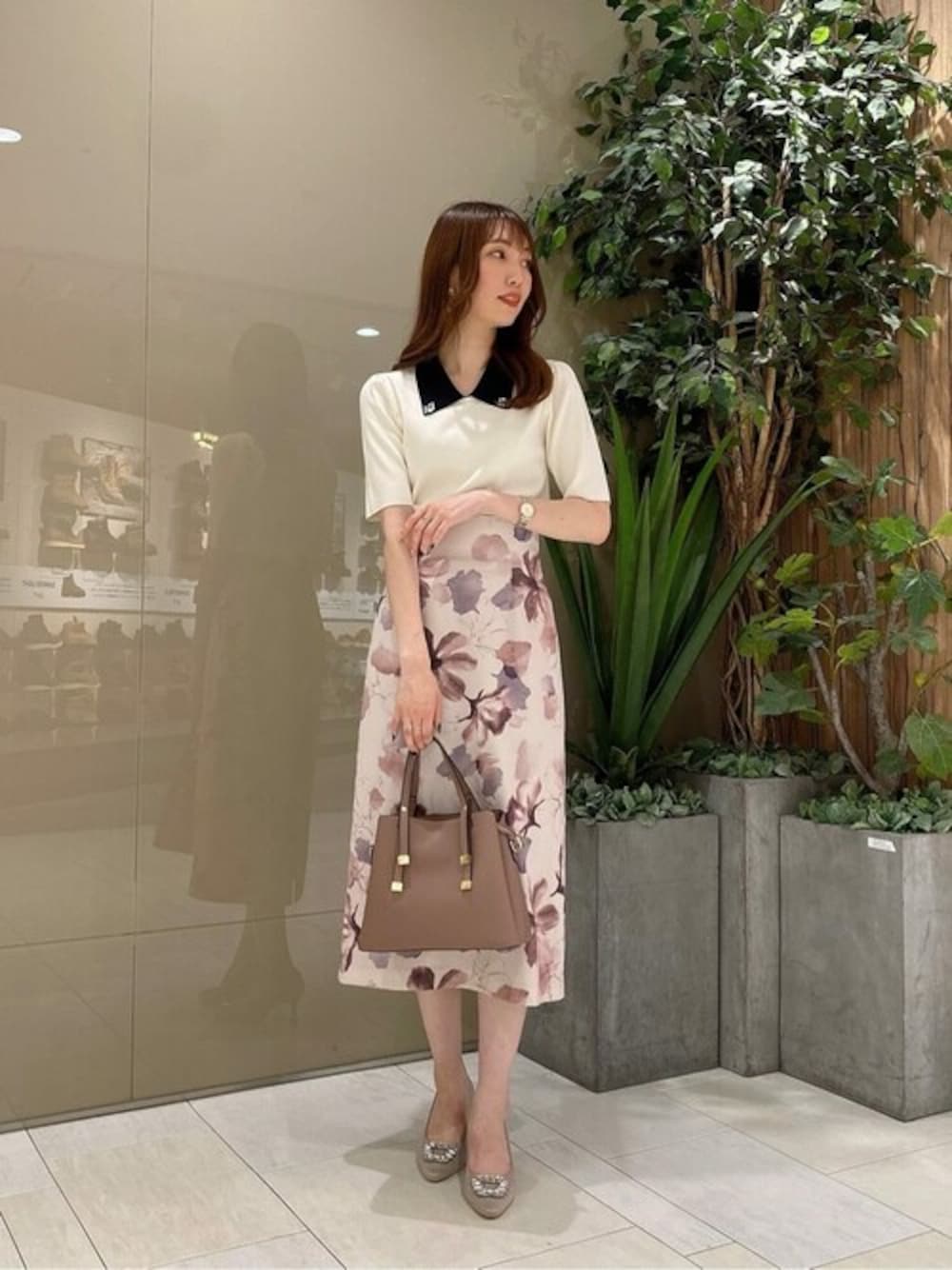 ホワイト系のニット/セーター、ピンク系のスカート、ブラウン系のショルダーバッグを着用したレディースの夏コーディネートの1枚目の写真