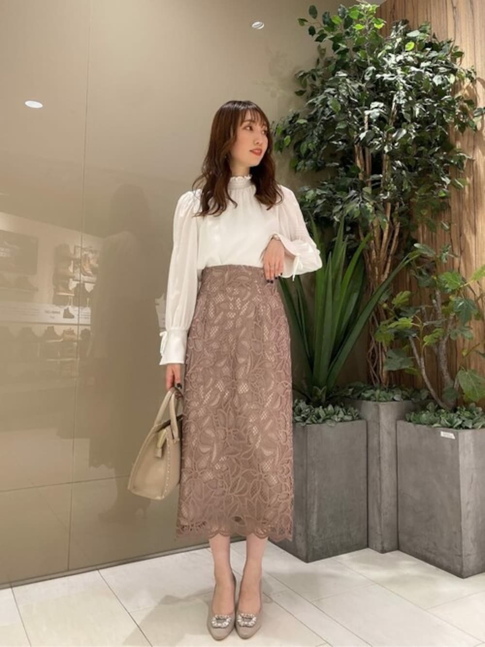 ホワイト系のシャツ/ブラウス、ベージュ系のスカート、ベージュ系のトートバッグを着用したレディースの秋コーディネートの1枚目の写真