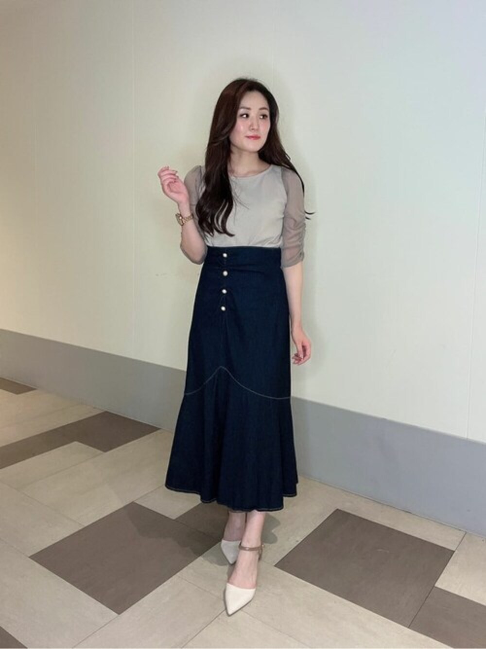 グレー系のTシャツ/カットソー、ブルー系のスカートを着用したレディースの秋コーディネートの1枚目の写真