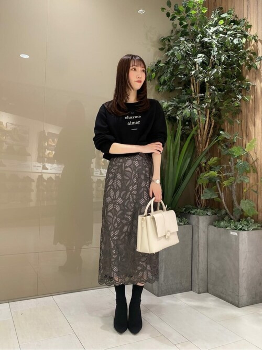 ブラック系のTシャツ/カットソー、グレー系のスカートを着用したレディースの秋コーディネートの1枚目の写真